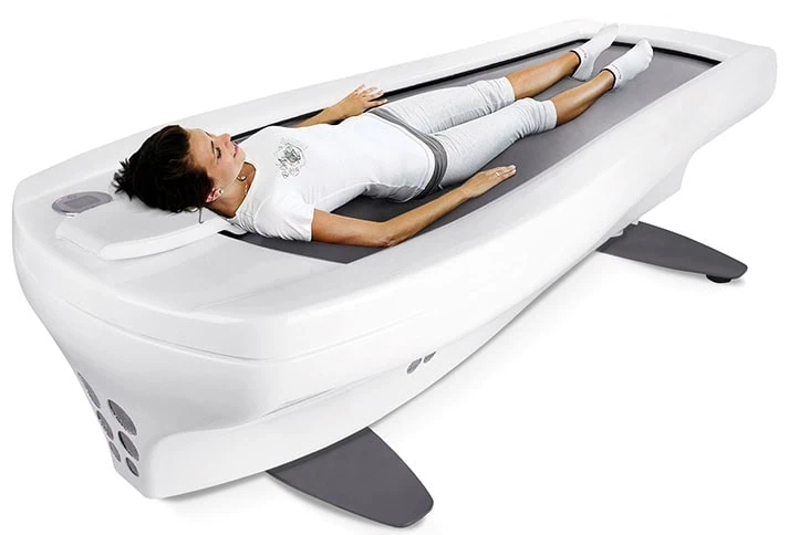 Hydromassageliege mit einer liegenden Person in entspannter Position auf der Liege, die für Hydrotherapie verwendet wird.